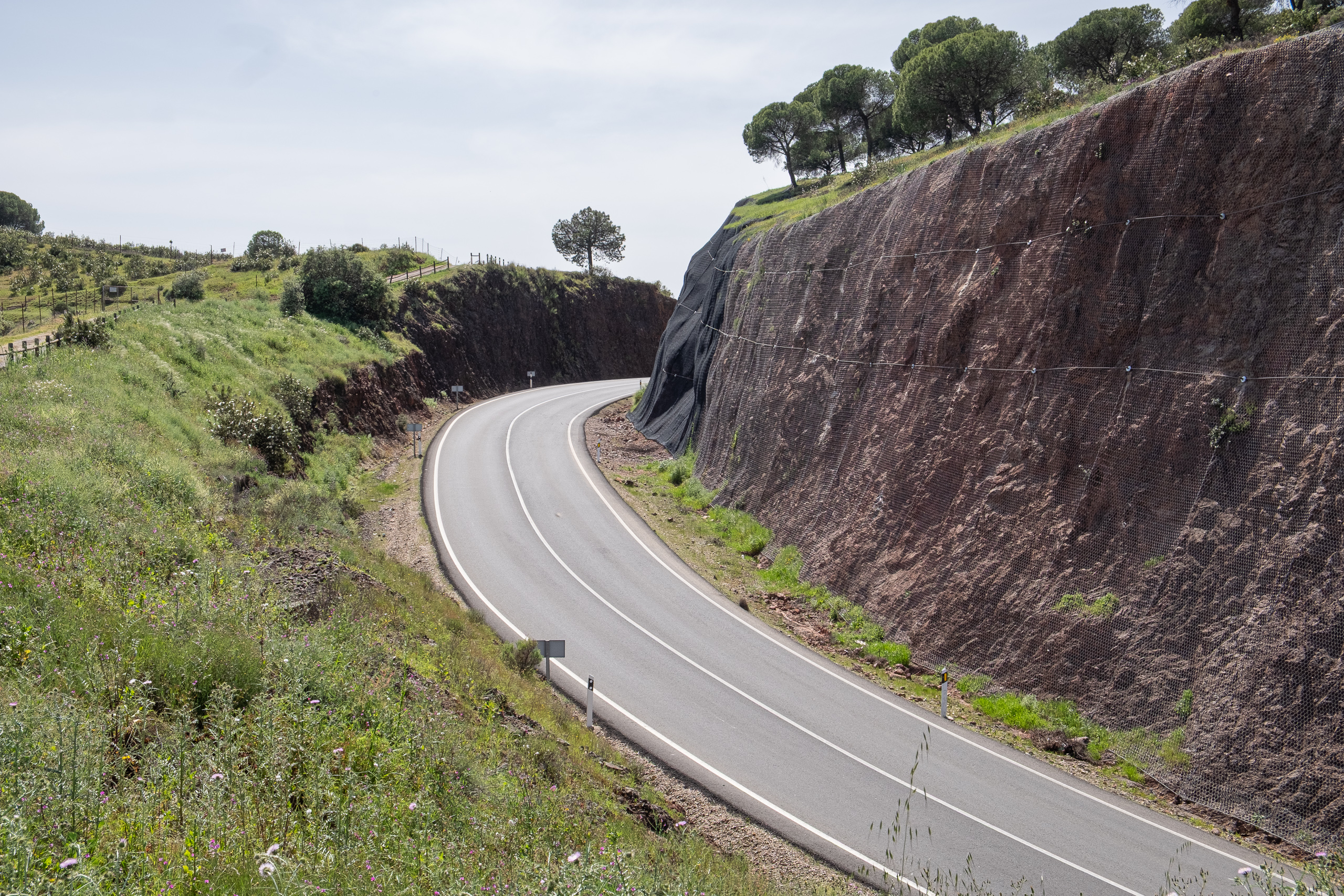 Kurvenreiche Straße durch einen roten Felseinschnitt